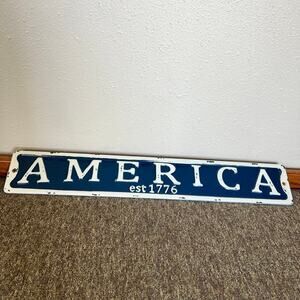 Metal, distressed AMERICA sign, 22 x 3 1/2”